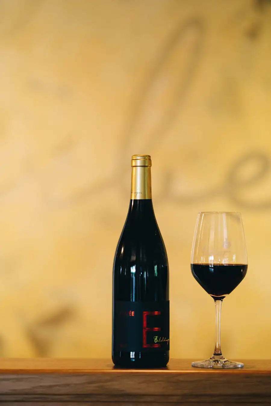 Erbeldinger Cuvée E Rotwein mit Flasche und Glas auf dem Tisch
